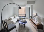 Thumbnail 45 of 46 - a living room with a white couch and a coffee table