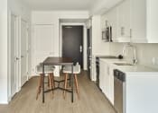 Thumbnail 25 of 46 - a kitchen with white cabinets and a wooden table and chairs