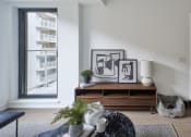 Thumbnail 34 of 46 - a living room with a couch and a table and a window