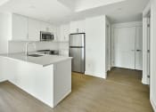 Thumbnail 14 of 46 - an empty kitchen with white cabinets and a stainless steel refrigerator
