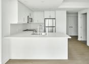 Thumbnail 37 of 46 - a large white kitchen with a white counter top and a white