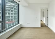 Thumbnail 7 of 46 - a hallway with white walls and wood floors and a large window