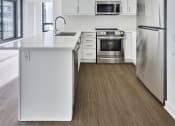 Thumbnail 29 of 46 - an empty kitchen with white cabinets and stainless steel appliances