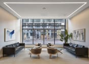 Thumbnail 9 of 46 - a living room with leather couches and chairs and a large window