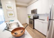Thumbnail 7 of 11 - a kitchen with stainless steel appliances and white cabinets