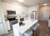 Thumbnail 10 of 11 - a kitchen with white cabinets and a white counter top