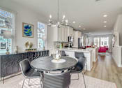 Thumbnail 11 of 19 - A modern dining room with a round table and chairs.