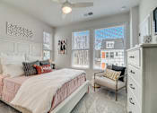 Thumbnail 31 of 38 - A bedroom with a bed, chair, and a ceiling fan.