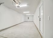 Thumbnail 38 of 38 - A long, empty hallway with a door at the end.