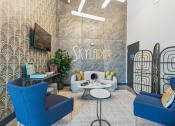 Thumbnail 5 of 32 - a living room with blue furniture and a sign on the wall