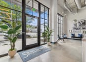 Thumbnail 10 of 32 - the lobby of a building with glass doors and a view of the street