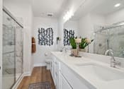 Thumbnail 2 of 19 - A bathroom with a white sink and a glass shower.