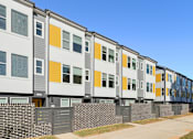 Thumbnail 3 of 19 - A row of modern townhouses with grey, white, and yellow exterior panels.