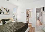 Thumbnail 11 of 18 - A bedroom with a large bed and a painting on the wall.