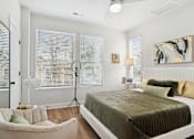 Thumbnail 4 of 18 - A bedroom with a bed, chair, and window with blinds.