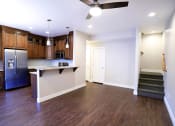 Thumbnail 17 of 26 - Large Front Room Space With Dark Wood Flooring, Light and Fan Fixture, Near Kitchen and Stairs at Moenave Tonwhomes in Springdale, Utah