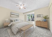 Thumbnail 6 of 23 - A bedroom with a bed, nightstand, and a ceiling fan.