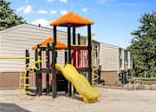 Thumbnail 4 of 23 - A playground with a yellow slide and an orange roofed structure.
