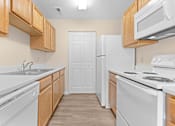 Thumbnail 11 of 22 - A kitchen with white appliances and wooden cabinets.