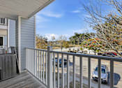 Thumbnail 8 of 19 - A balcony with a railing and a car parked in the background.
