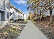 Thumbnail 4 of 19 - A concrete walkway leads between two rows of houses.