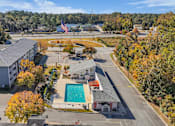 Thumbnail 5 of 19 - An aerial view of a school with a pool and a flag.