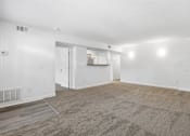 Thumbnail 12 of 19 - A large, empty room with a carpeted floor and white walls.