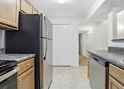 Thumbnail 15 of 19 - A kitchen with black appliances and wooden cabinets.