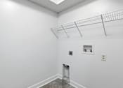 Thumbnail 17 of 19 - A white room with a metal rack on the ceiling and a small shelf with two objects on it.