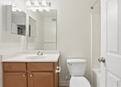 Thumbnail 18 of 19 - A white toilet sits next to a sink in a bathroom.