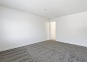 Thumbnail 14 of 19 - A room with a carpeted floor and a door.