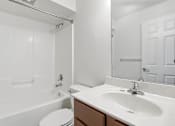 Thumbnail 19 of 19 - A white bathroom with a toilet, sink, and mirror.
