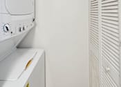 Thumbnail 14 of 14 - A white washing machine and dryer in a small laundry room.