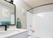 Thumbnail 6 of 15 - a bathroom with a sink and a toilet and a shower