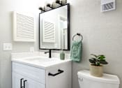 Thumbnail 5 of 15 - a small bathroom with a toilet and a sink and a mirror