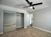 Thumbnail 1 of 15 - an empty living room with a ceiling fan and a mirrored closet