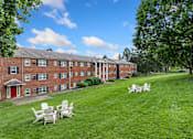 Thumbnail 18 of 51 - A red brick building with white chairs in front of it.