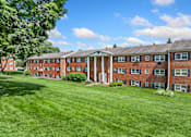 Thumbnail 27 of 51 - A large red brick building with a green lawn in front.