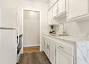 Thumbnail 36 of 51 - A kitchen with white cabinets and a marble countertop.