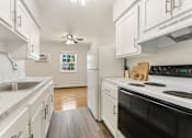 Thumbnail 37 of 51 - A kitchen with white cabinets and a black stove top oven.