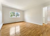 Thumbnail 28 of 51 - A room with wooden floors and a window showing trees outside.