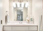 Thumbnail 7 of 22 - Well-lit vanities with extra cabinet storage in every apartment.