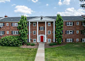 Thumbnail 30 of 51 - A red brick building with a white door and windows.