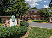 Thumbnail 29 of 51 - A sign for Society Hill Apartments stands in front of a brick building.