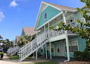 Thumbnail 14 of 23 - A blue house with a white staircase leading to the front door.