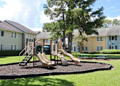 Thumbnail 19 of 24 - A playground with a slide and a green slide cover.