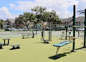 Thumbnail 24 of 24 - A playground with a green surface and a blue bench.