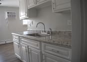 Thumbnail 49 of 51 - a view of a kitchen with white cabinets and a sink