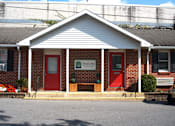 Thumbnail 39 of 51 - a red brick building with two red doors and a sign on the front