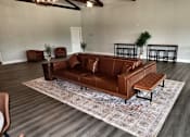 Thumbnail 46 of 56 - A brown leather couch with a matching ottoman in a room with a rug.